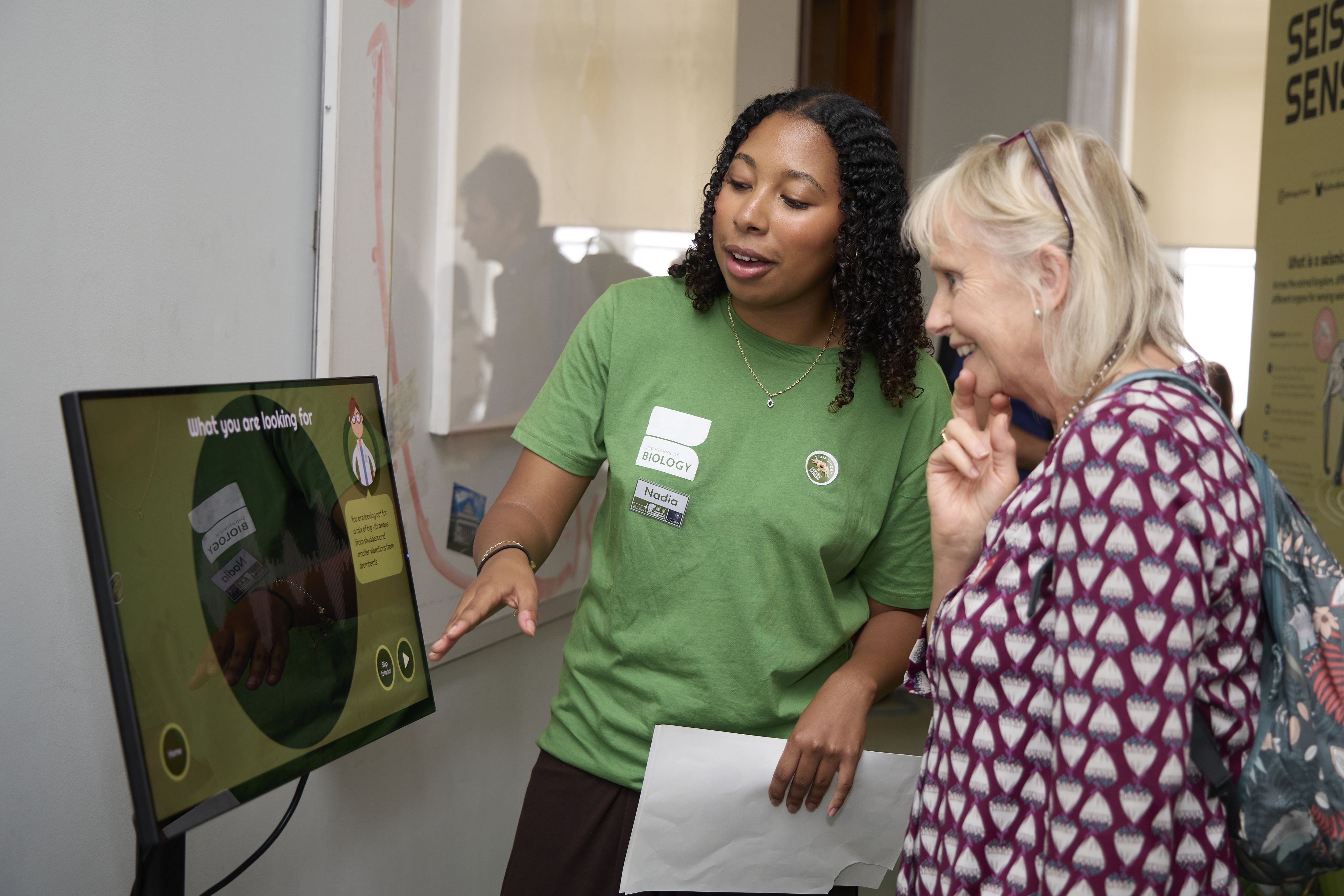 A researcher and visitor playing the seismic scientist training academy game 